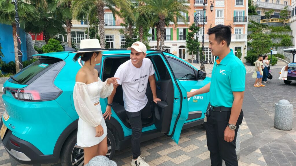 Tài xế Xanh SM hỗ trợ khách lên xe taxi VinFast xanh ngọc