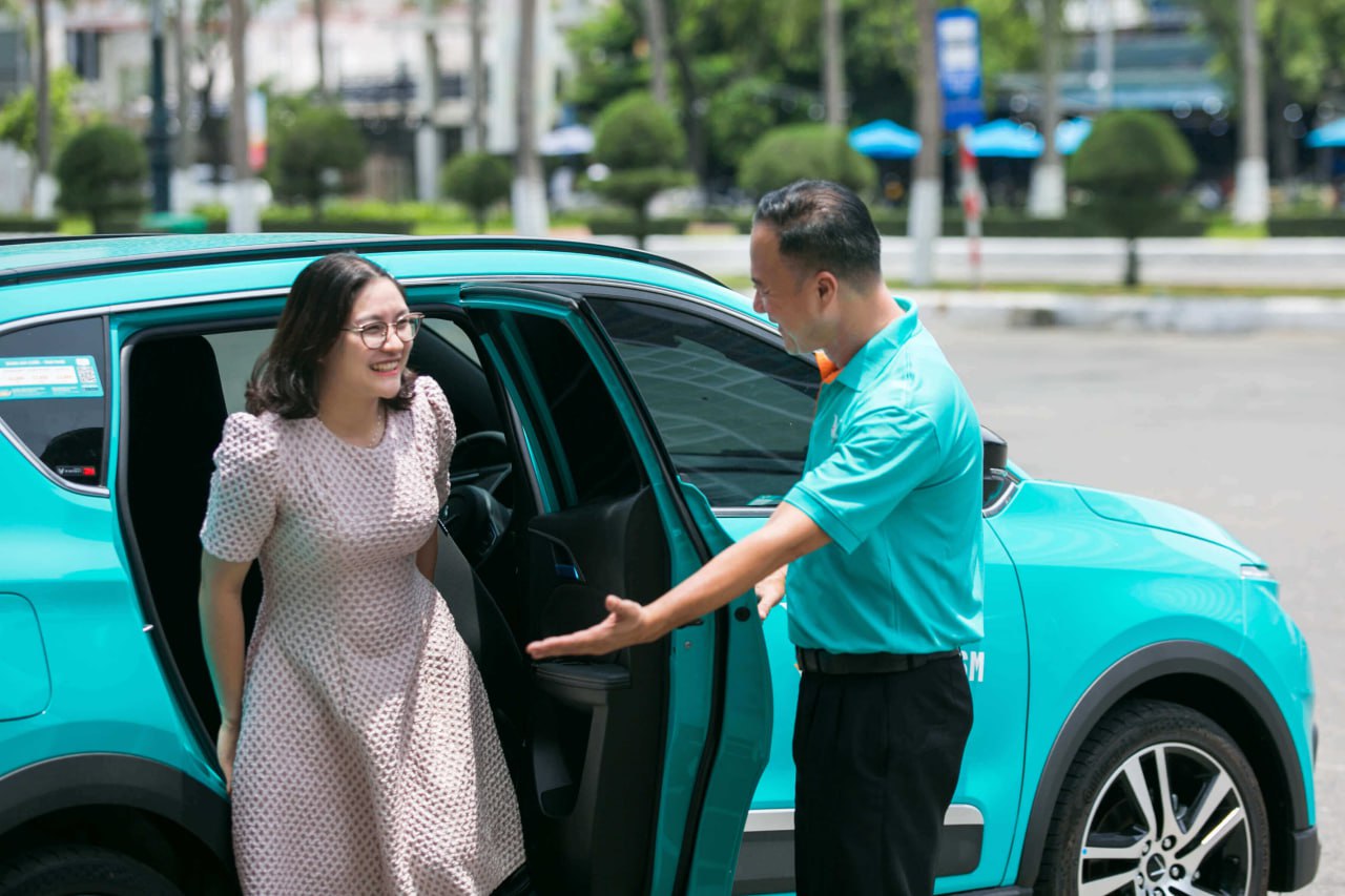 Tài xế hỗ trợ khách lên xe taxi điện